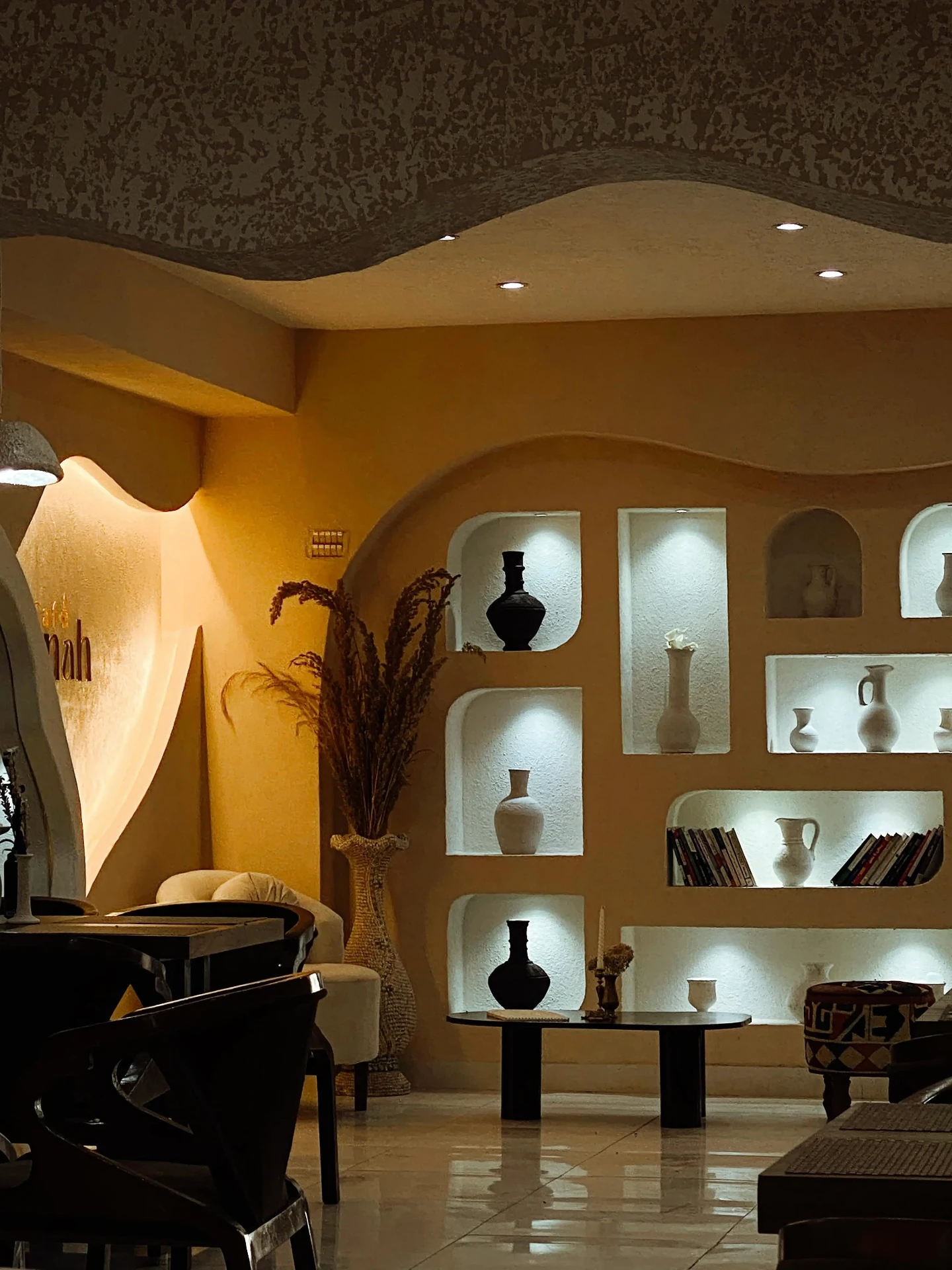 Warm interior of Cafè Panah with lit display niches