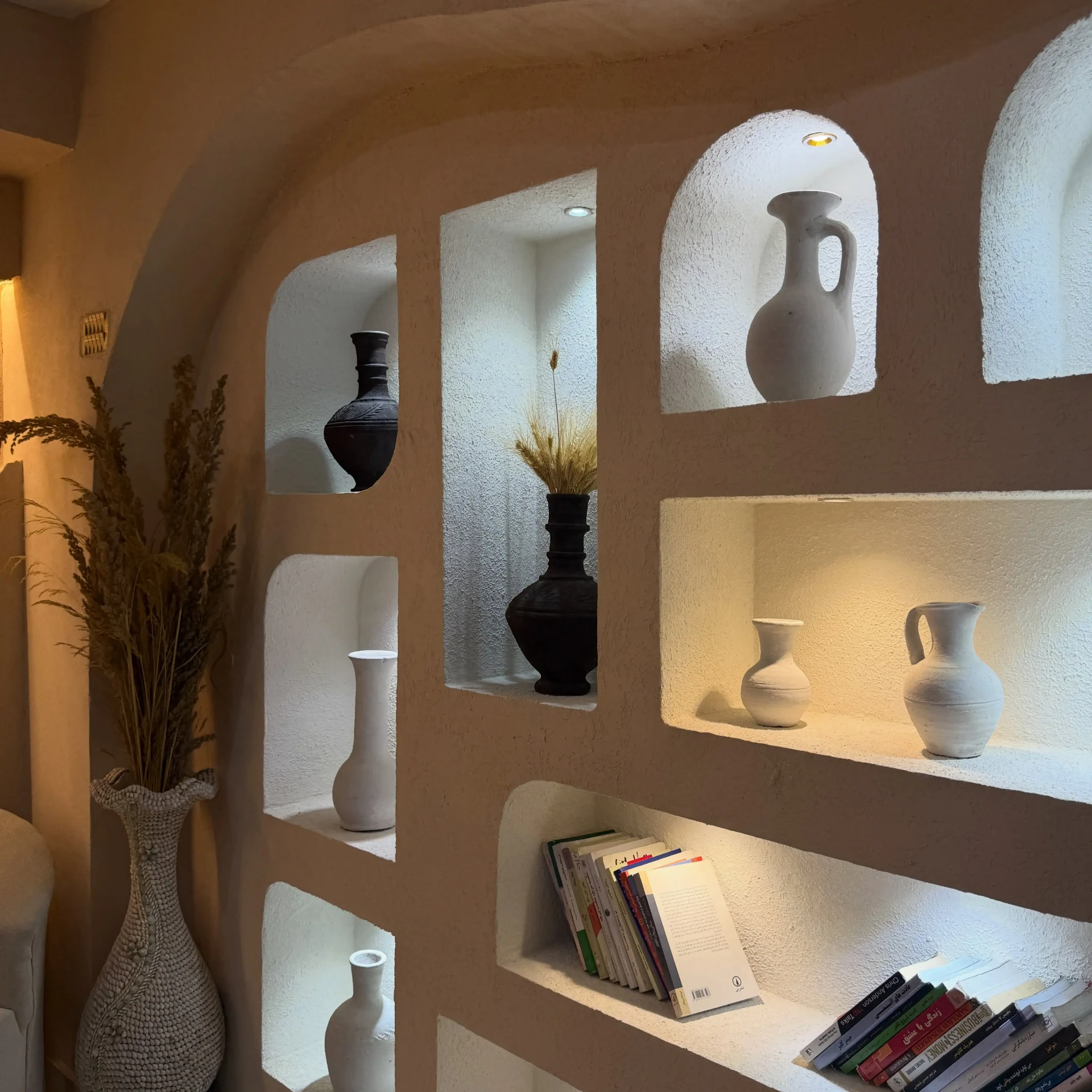 Handmade pottery in illuminated wall niches